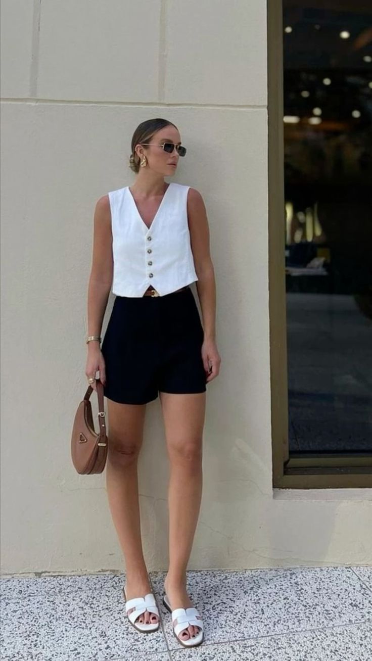 White sleeveless vest with black high-waisted shorts 